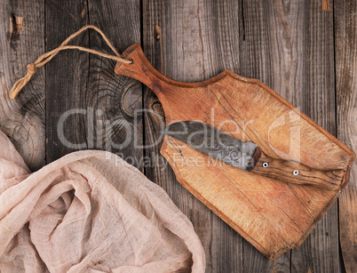 empty old brown wooden cutting board with handle and gray textil