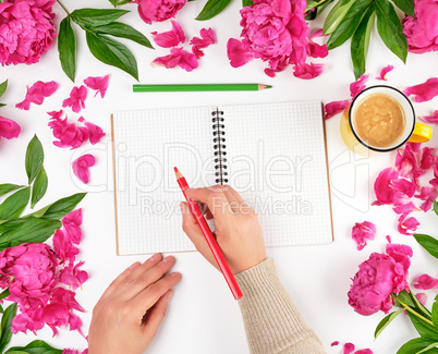 open empty notebook in a cage and two female hands