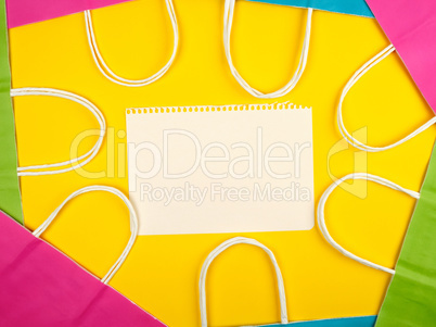 blank white sheets and multi-colored paper shopping bags