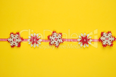 Christmas garland with carved felt snowflakes on a red ribbon
