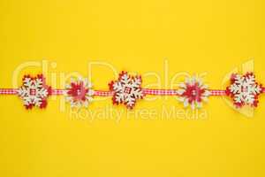 Christmas garland with carved felt snowflakes on a red ribbon