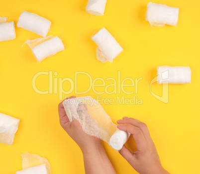 hand wrapped with white gauze bandage, yellow background