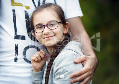 Father's hand hugs daughter