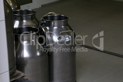 Empty milk cans stand on a farm