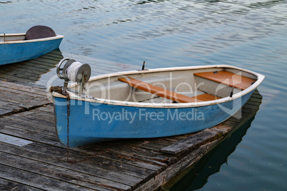 Blue fishing boat stands on a quiet lake