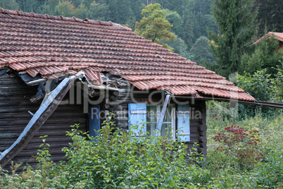 Old wooden house in disrepair on the edge of the village