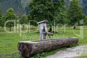 Well and Water trough made out of tree trunk in the alps
