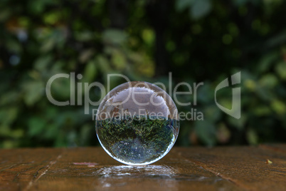 Glass ball lies on a wooden table