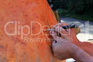Mans hands close-up carve pumpkinat the autumn holiday
