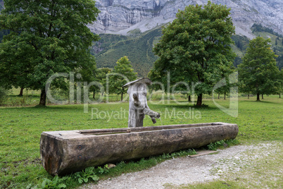 Well and Water trough made out of tree trunk in the alps