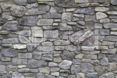 The wall of the house made of natural gray stone