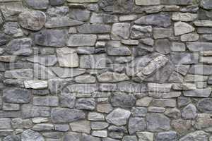 The wall of the house made of natural gray stone