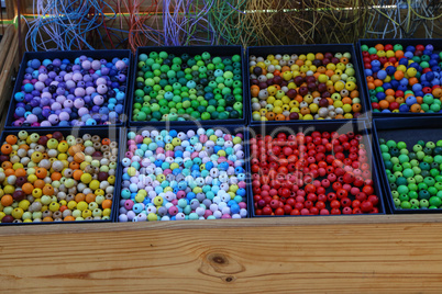 Various colorful plastic beads in trays for sale