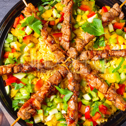 Lamb skewers with curry rice and different vegetables