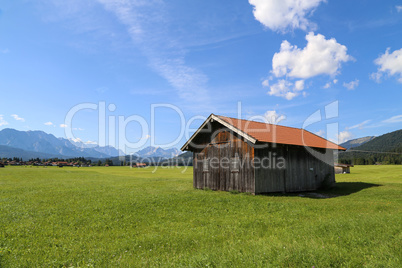 Mountain huts on green meadows in the Alps