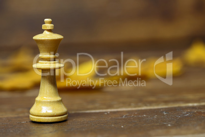 White Queen chess piece on blurred brown background