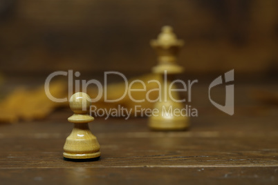 Chess pieces on a blurry brown background.dreams of becoming a queen