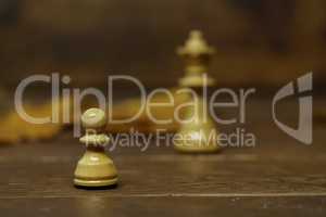 Chess pieces on a blurry brown background.dreams of becoming a queen