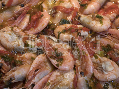 Shrimps fried on pan with fresh herbs and tomatoes.