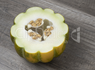 Half of ripe fresh melon with seeds isolated on wooden backgroun