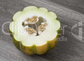 Half of ripe fresh melon with seeds isolated on wooden backgroun