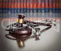 Gavel and Stethoscope on Wooden Table With Law Books In Backgrou