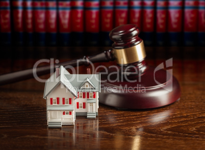 Gavel and Small Model House on Wooden Table.