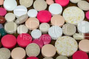 Various pills and capsules lie on the table