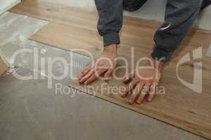 The worker installing new vinyl tile floor