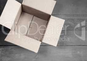 Cardboard box for postal items on a wooden background.