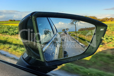View of the road in the side mirror of the car