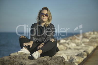 Blonde girl sitting on the rocks #3