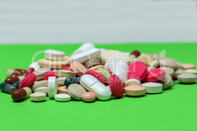 Various pills and capsules lie on the table