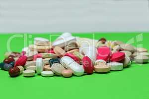 Various pills and capsules lie on the table