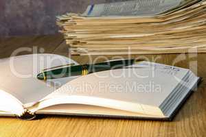 Pen lying on calendar or organizer on desk in office