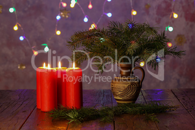 Red Advent candles stand on a wooden table