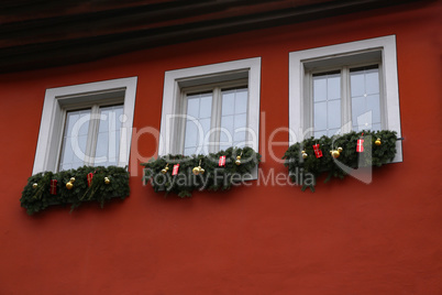 Decoration of windows of spruce branches and toys for Christmas