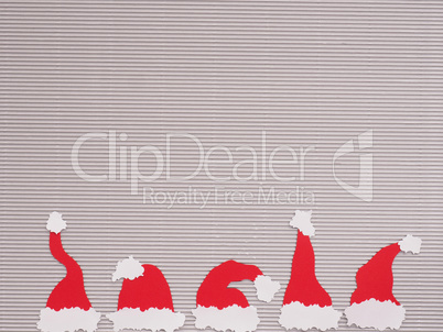 Five handmade hats of Santa on a paper background