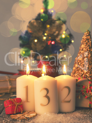 Three Advent candles burning with gift boxes, vintage tone styli