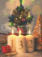 Three Advent candles burning with gift boxes, vintage tone styli
