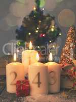 Four Advent candles burning with gift boxes, vintage tone styliz