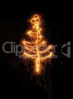 A Christmas tree drawn with a sparkler on black background
