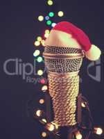 Close up of a microphone with the hat of Santa and blurred light
