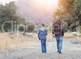 Mixed Race Father And Son Outdoors Walking With Fishing Poles