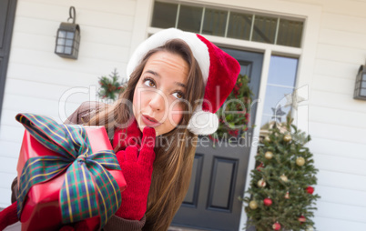 Young Girl Holding Wrapped Gift Standing on Christmas Decorated