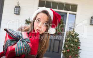Young Girl Holding Wrapped Gift Standing on Christmas Decorated