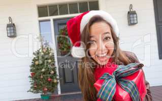 Young Girl Holding Wrapped Gift Standing on Christmas Decorated