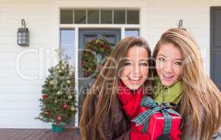 Young Mixed Race Girls Holding Wrapped Gift Standing on Christma