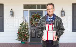 Warmly Dressed Man Holding Gifts Standing on Christmas Decorated