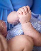 Close-up Of Infant Hands While Laying on Lap of Mother